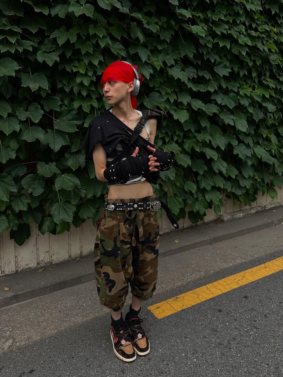 Inferno with camouflage trousers and a black top, outdoors