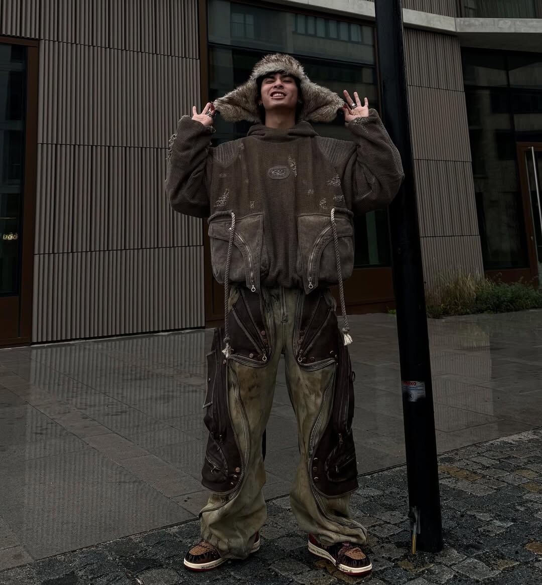 Inferno with an oversized brown jacket and wide trousers